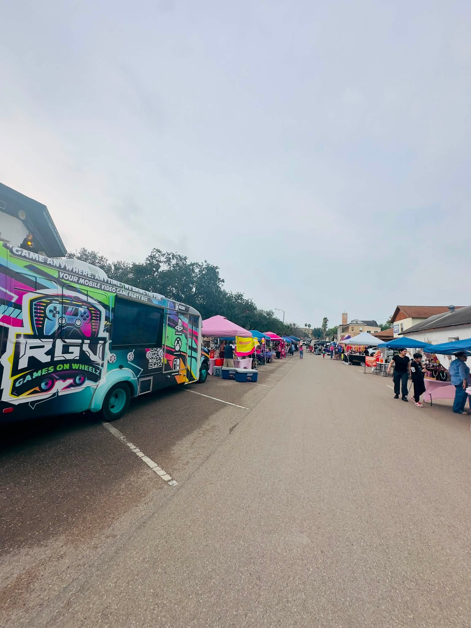 The RGV Games on Wheelz mobile gaming bus parked at a Rio Grande Valley community event with its outdoor screen mounted on the side