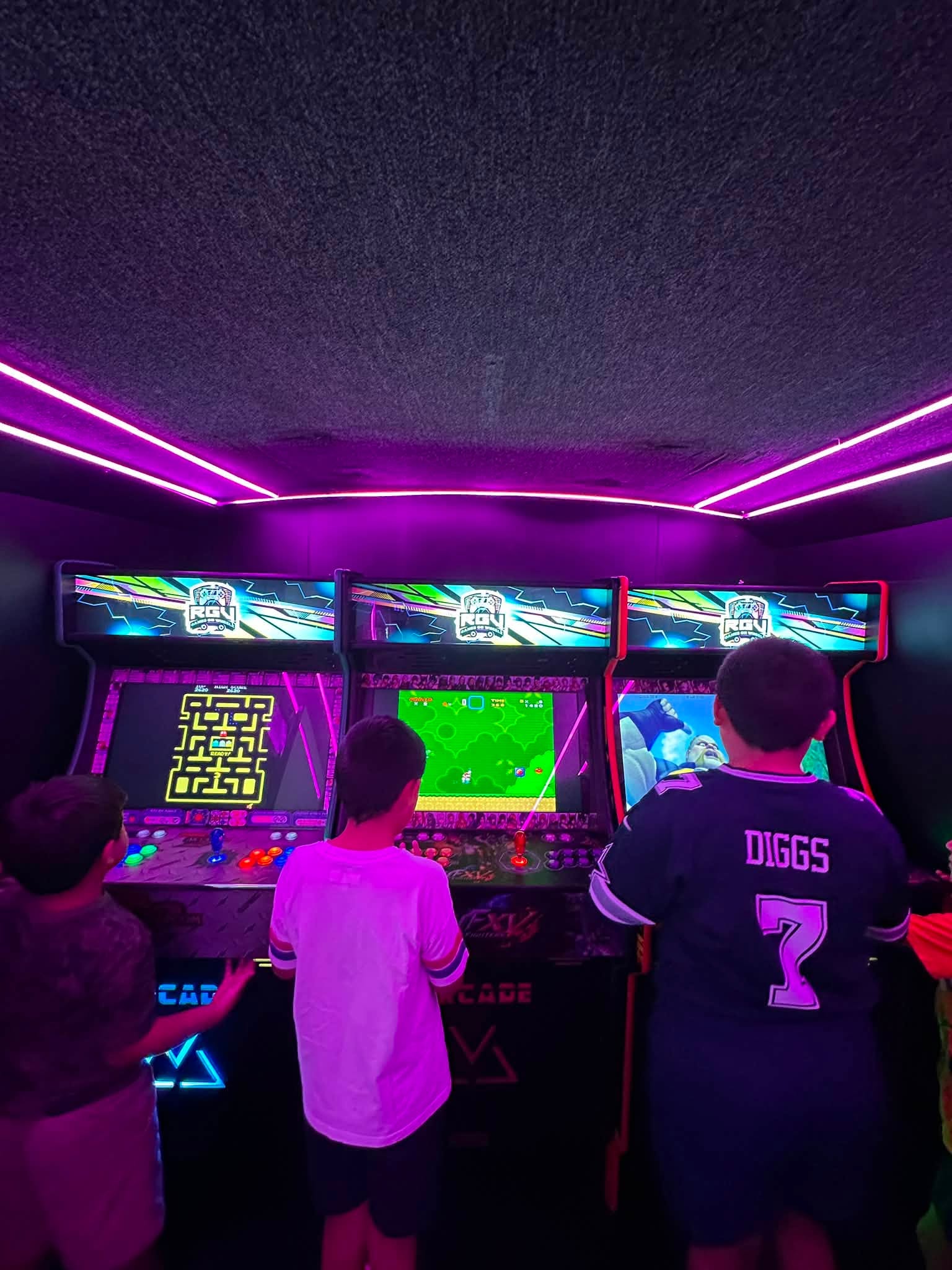Kids playing side by side at the custom arcade cabinets inside the RGV Games on Wheelz bus